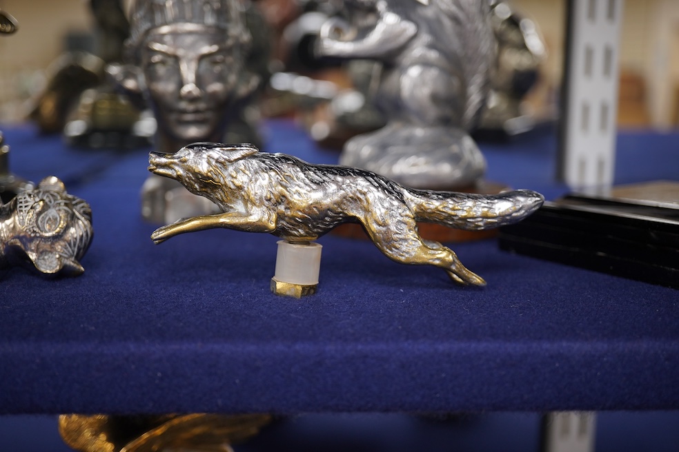 Seven chrome, brass and aluminium car mascots, etc. including an unusual and comical aluminium car mascot in the form of a squirrel holding a nut, together with a standing bear, an Art Deco winged head, a ram, a running